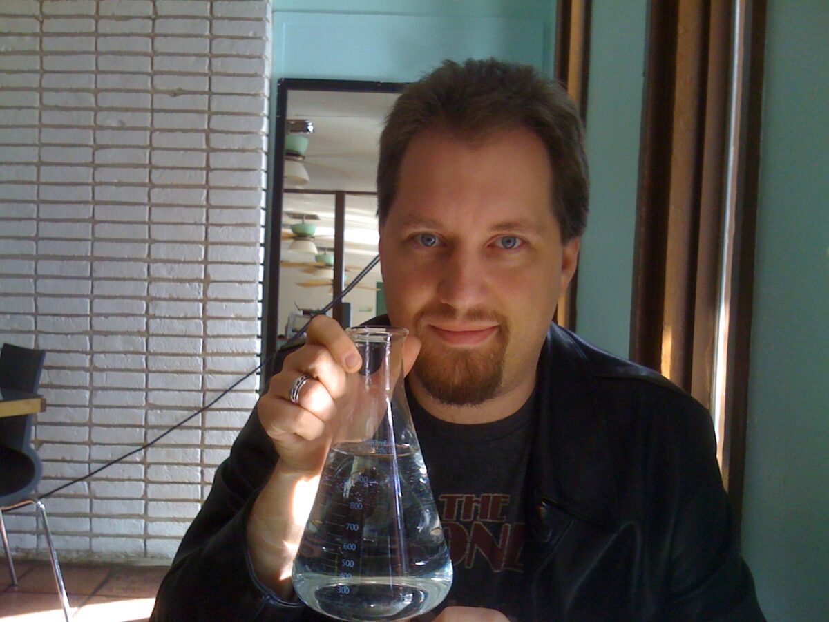 Park, holding a beaker of water.